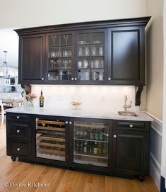 a kitchen with wooden floors and black cabinets