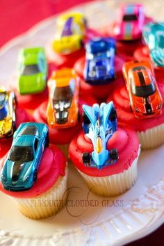 cupcakes with cars on them sitting on a plate