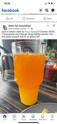 an orange juice in a blender sitting on top of a table