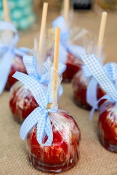 candy apples wrapped in cellophane and tied with blue ribbon are ready to be eaten