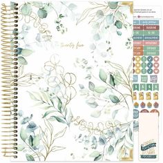 a spiral notebook with watercolor leaves on it