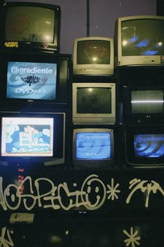 there are many old tvs with graffiti on them