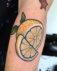 a tattoo with a lemon on the arm