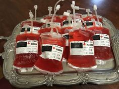 several bottles filled with blood sitting on top of a silver tray