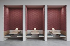 two sinks in the middle of a room with red walls and hexagonal tiles