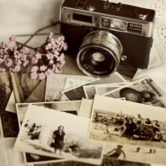 an old camera and some pictures on a table