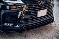 the front end of a black car with chrome grills on it's grille