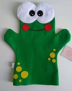 a green hand puppet with eyes and hands