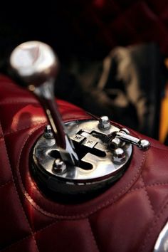 a close up of a red purse with a metal clock on it