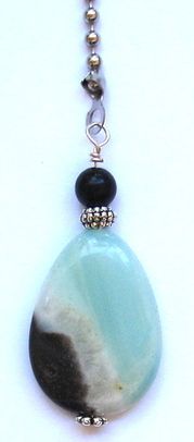 a necklace with a stone and bead hanging from it's end on a chain