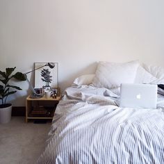 a bed room with a laptop computer on top of it