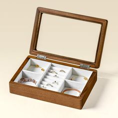 an open wooden jewelry box with rings and bracelets