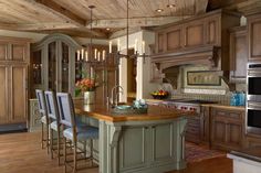 a large kitchen with wooden floors and an island in the middle, surrounded by chairs