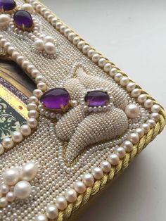 a close up of a purse with pearls on it