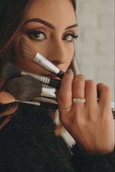 a woman with makeup brushes in her hand