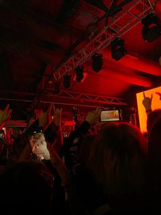 a group of people standing in front of a screen with their hands up to the sky