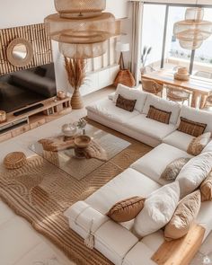 a living room filled with lots of white furniture and large window overlooking the ocean in front of it