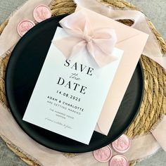 save the date card on top of a plate with pink and white wax stamping