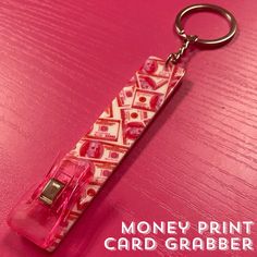 money print card graber keychain sitting on a pink surface with the words money print