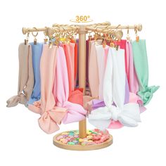 an assortment of colorful scarves hanging on a rack with doughnuts and sprinkles