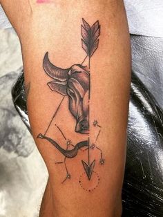 a bull with an arrow tattoo on its leg is shown in black and grey ink