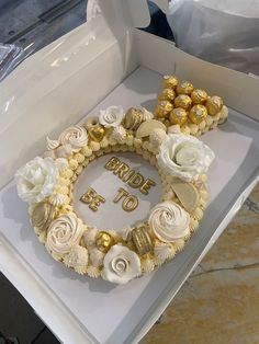 a cake in a box with flowers and chocolates on the top that says bride to be