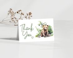 a thank you card with a bear sitting on the ground in front of some flowers