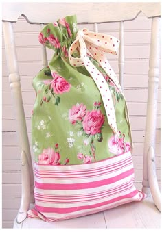 a green floral bag sitting on top of a white chair