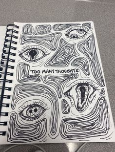 a spiral notebook with the words too many thoughts on it and an eye drawn in black ink