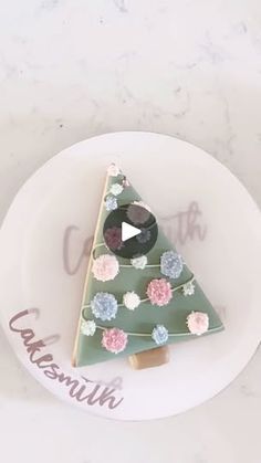 a decorated christmas tree on a plate with the word congratulations written in pink and blue