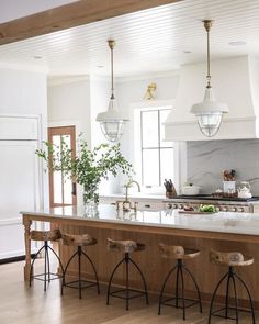 a kitchen with two stools next to an island