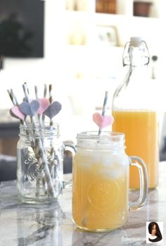 two mason jars filled with drinks sitting on top of a counter