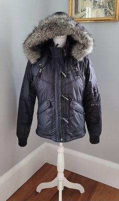 Vintage  2000s Black Triple five good essentials Y2K down bomber jacket. Oversized hood with fake fur lining  and trim. Zip up, all pockets are real, has a really nice sheen to it and is waterproof. Faux horn closures. Lots of grommet detail Measures Length 23" Shoulders 43" Bust 44" Waist 38 Oversized Hooded Y2k Outerwear, 2000s Jacket, Fur Trim Coat Y2k, Fur Hood Jacket Y2k, Y2k Faux Fur Jacket, 2000 Fur Coat, Fur Lined Jacket, Oversized Faux Fur Coat, Vintage Faux Fur Coat