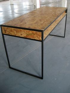 a table made out of plywood and black metal with a wooden drawer on top