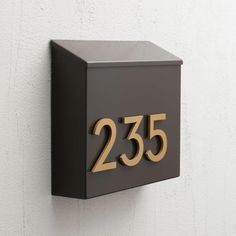 a house number sign mounted to the side of a wall