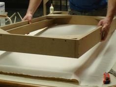 a man is making a box out of cardboard