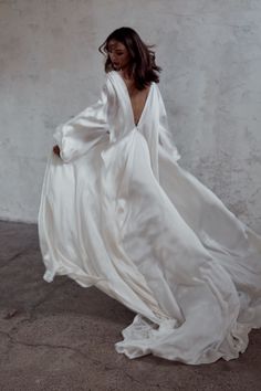 a woman in a white dress is posing for the camera