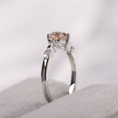 an engagement ring with a pink diamond on top