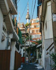 an alley way with buildings and a tall tower in the backgroung area