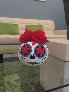 a glass table topped with a white and red skull ornament on top of it