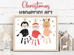 christmas handprint art is displayed in front of a white wooden background with holiday decorations