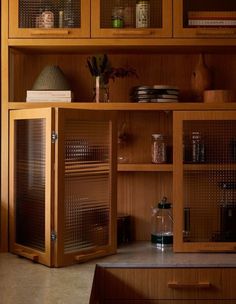 a wooden cabinet with glass doors and shelves