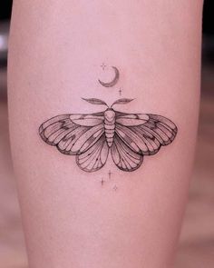 a small moth tattoo on the right thigh, with a crescent moon in the background