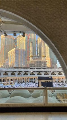 an arched window with a view of the grand mosque and other buildings in the background