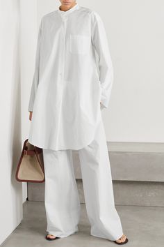 The Row's 'Come' tunic has a chic, minimal silhouette that ensures endless styling potential - wear yours with skinny jeans or half-tucked into the brand's tailoring. Made from cotton-poplin, it has a loose shape with a curved high-low hem and fastens with lustrous mother-of-pearl buttons. Chic Cotton Tunic With Relaxed Fit, Chic White Relaxed Fit Tunic, White Chic Relaxed Fit Tunic, Elegant Cotton Tunic For Spring, Chic Shirttail Hem Tunic For Spring, Elegant Fall Tunic With Relaxed Fit, Spring Tunic For Workwear, Spring Workwear Tunic With Shirttail Hem, Chic Oversized Tunic For Work