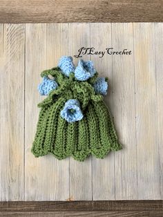 a green knitted bag with blue flowers on it