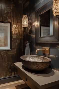 a bathroom with a large bowl sink in the center and two lights on the wall