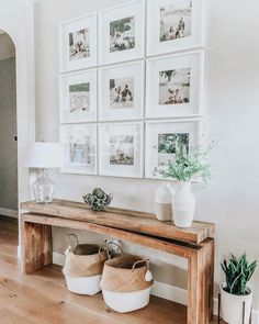 a wooden bench sitting in front of a wall with pictures on it