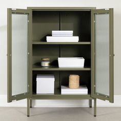 a green metal cabinet with shelves and baskets