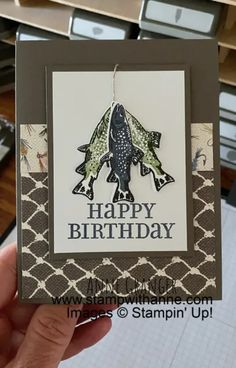 a hand holding up a birthday card with an image of a rocket ship on it